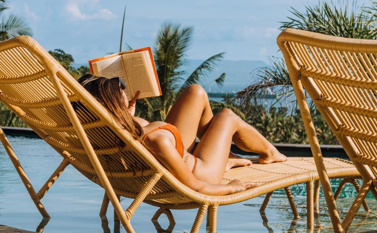 Neano Escape Hotell Manggis Eksteriør bilde A woman reading a book on a beach